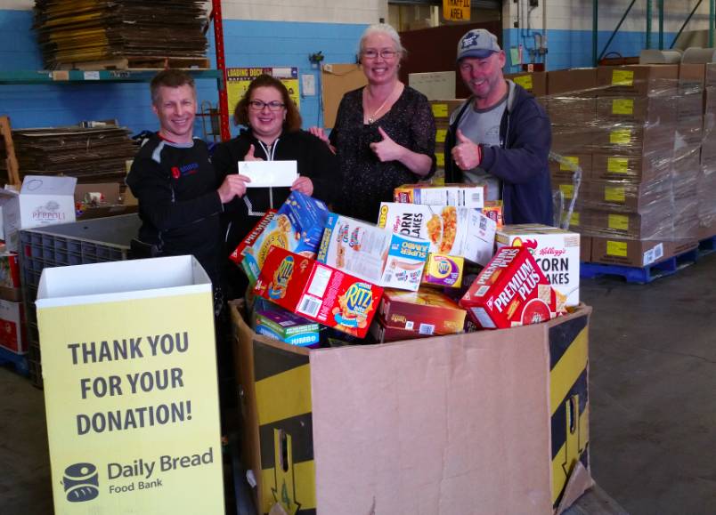 Sam dropping off food and a cheque at the Daily Bread Food Bank